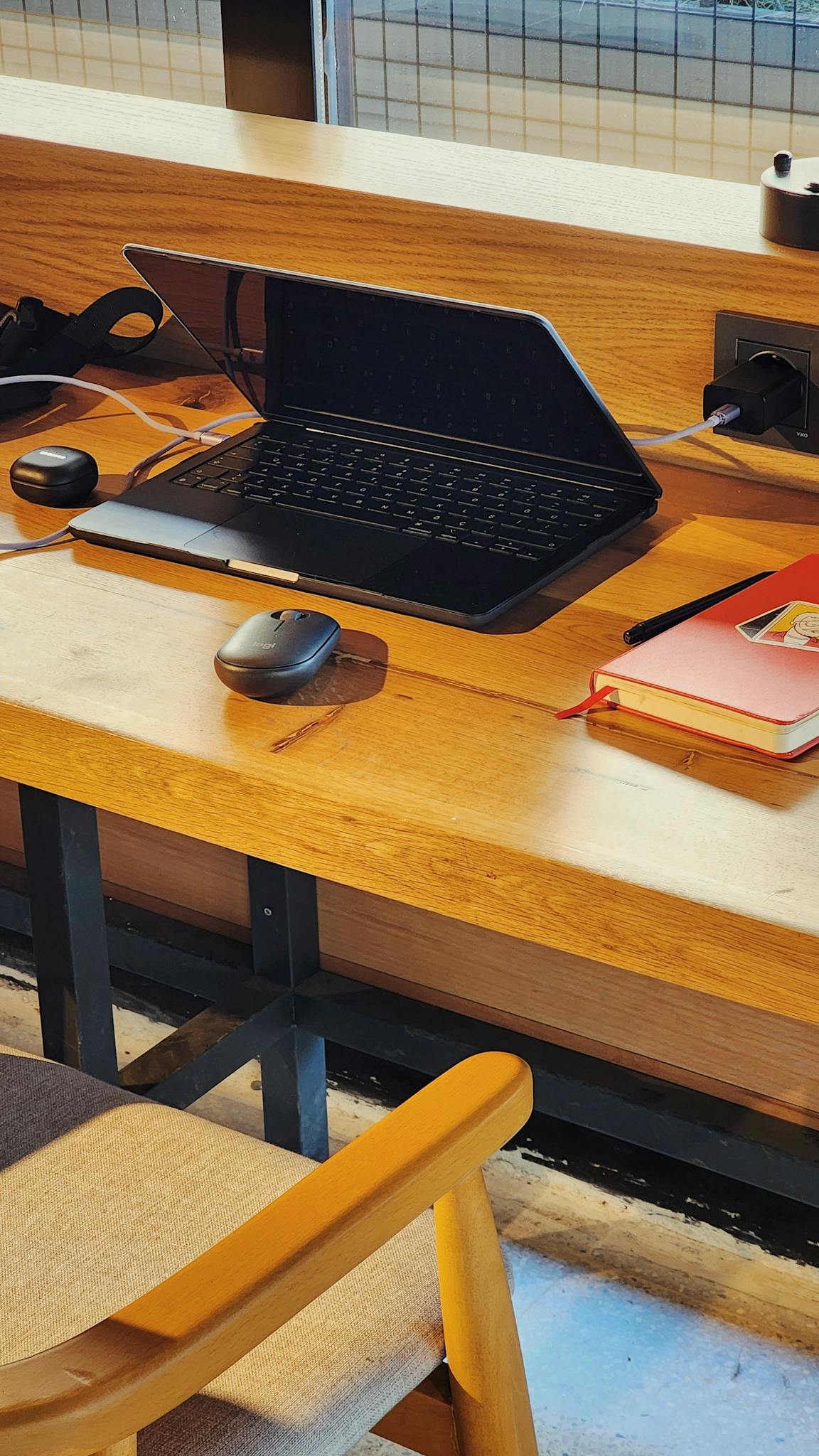 Stylish office desk featuring a laptop, wireless mouse, and notebooks, ideal for productivity.